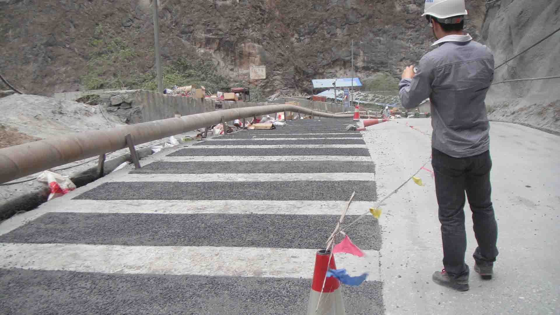 此前为了防滑和降速,在原混凝土路面凿成宽20cm,深10cm的沟槽,通过